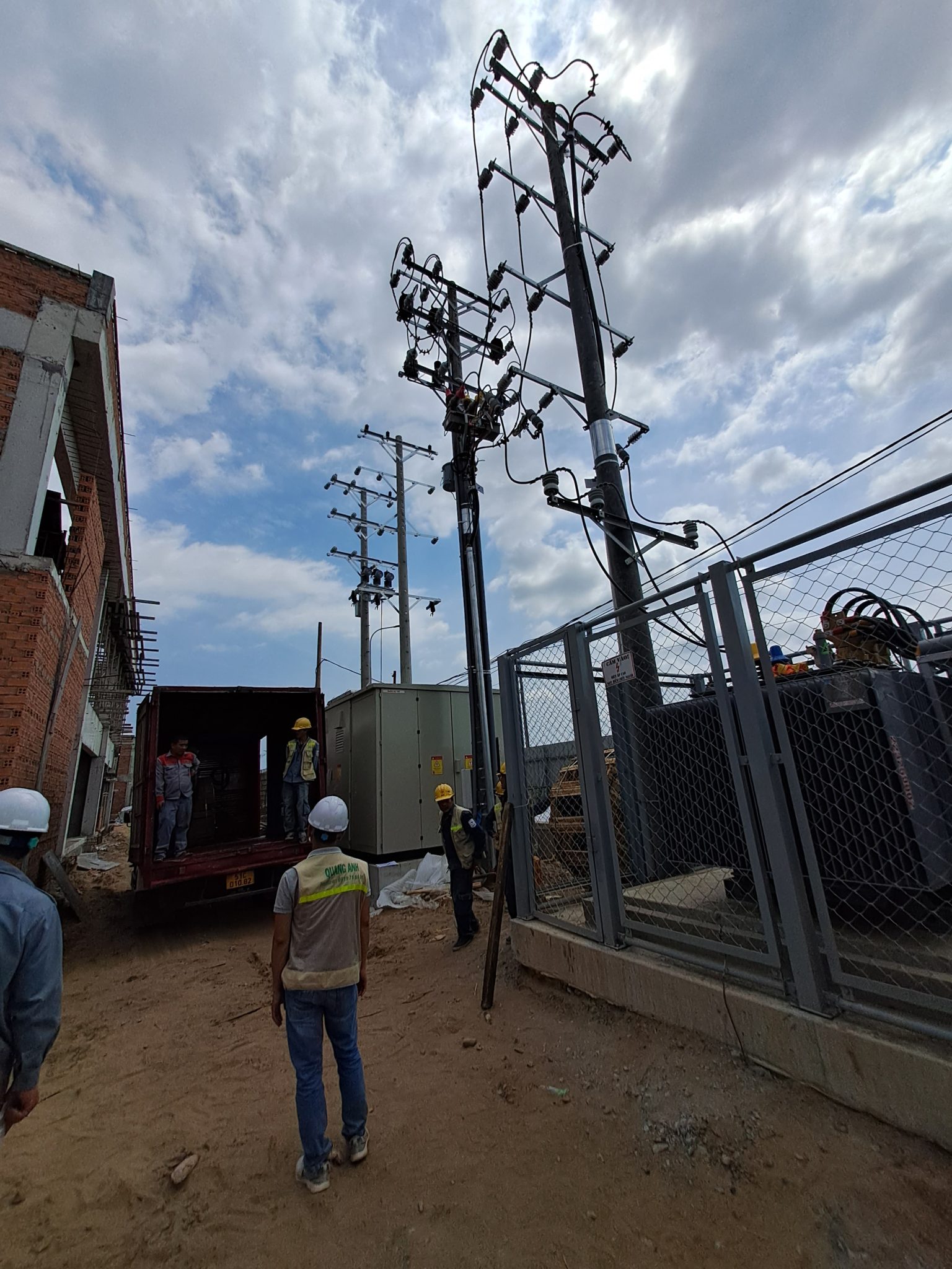 Worker installing an industrial transformer station.