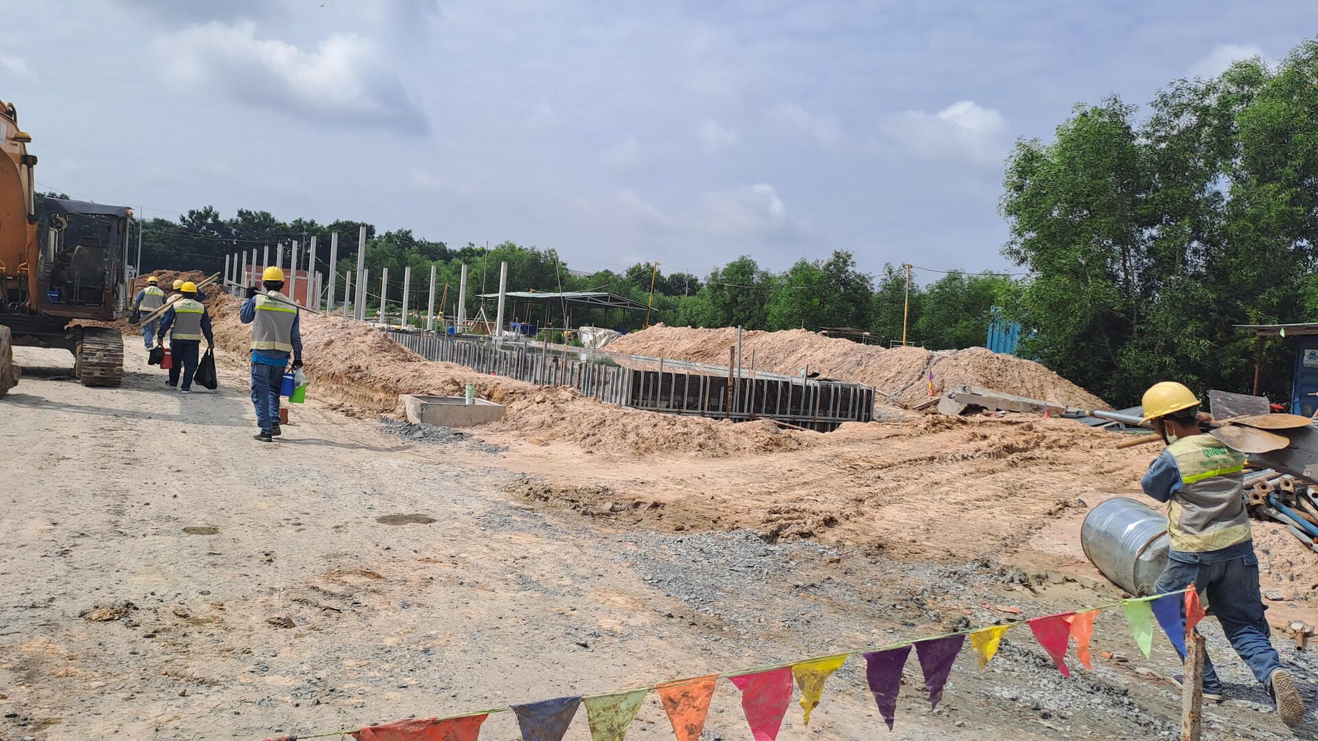 QuangAnhcons archive showing personnel carrying equipment along a construction access route