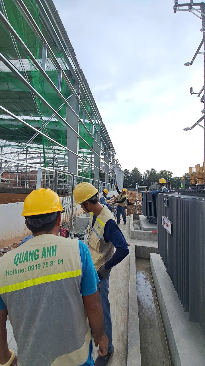 QuangAnhcons site team walking beside construction access route and electrical equipment work area